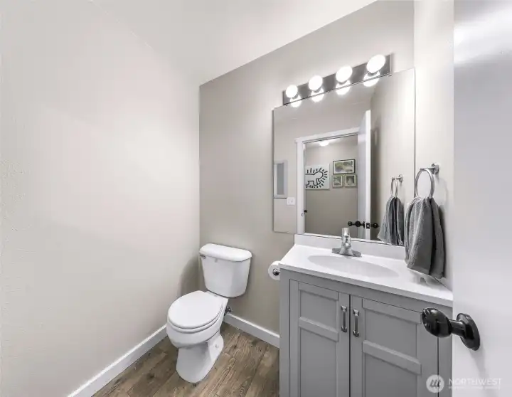 Powder room with newer vanity, lighting, flooring, and quartz countertops!