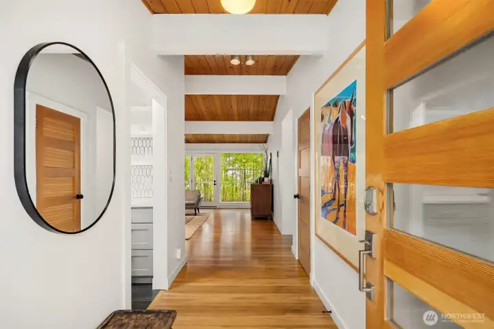 A new wood & glass door opens to the light, lofty interiors beyond.