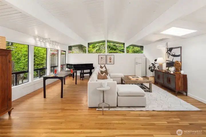 Another spacious living area basks in the light of clerestory windows, a bright, skylight, and an expanse of windows overlooking the front patio.