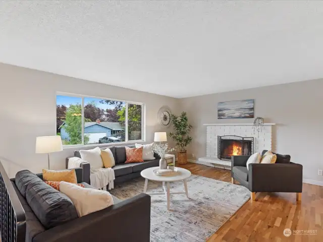 The spacious living room features a wood burning fireplace. Refinished hardwood floors run through most of the main living areas and the interior is also freshly painted.