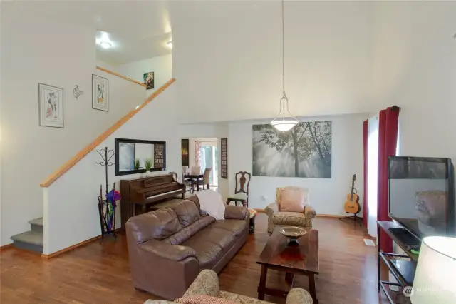 Beautiful living room with tall ceilings and an open staircase to the second floor.    Notice the gorgeous hardwood floors which are throughout the main floor.