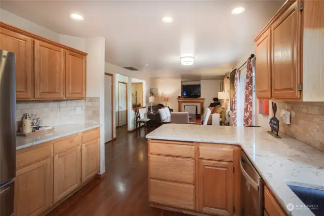 Kitchen with quartz countertops, stainless steel appliances, and wood cabinets.