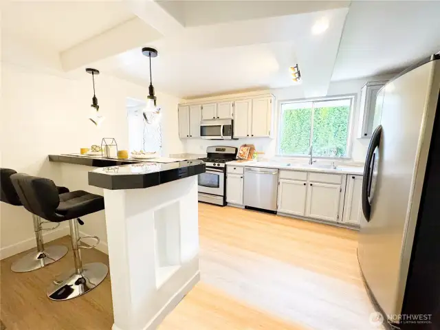 This remodeled kitchen offers a built-in bar area while giving ample kitchen space with a pantry.