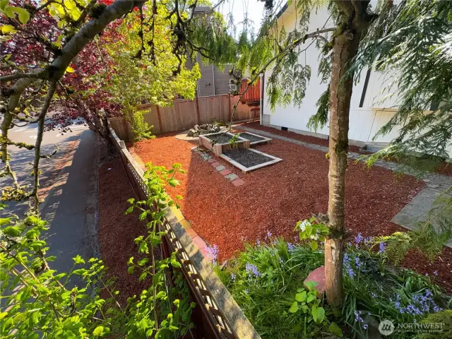5 of top 5 photos: This home provides ample space for gardening with multiple garden boxes. There is also a wood-burning fireplace located on the side of the house.