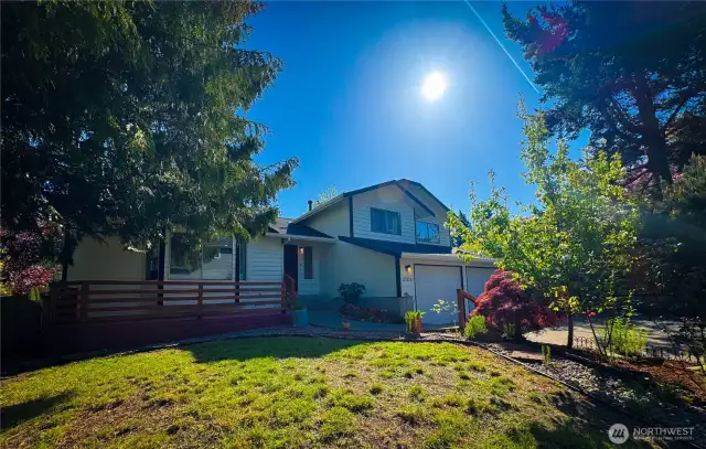 The house is nicely shaded, and the yard is landscaped. There is also a front porch/deck at the entrance.