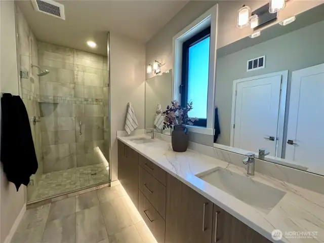 Primary bath features quartz counters, double vanity and walk-in fully tiled glass shower