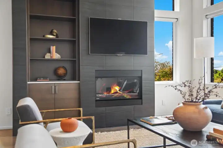The fireplace wall featuring a gas fireplace, built-in walnut cabinetry, all wrapped in tile is the focal point of the living space