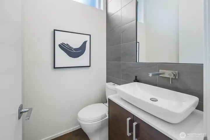 Powder room is tucked away from the great room spaces next to the office/den