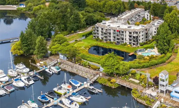 Discover effortless elegance at Harbour Village Condominiums, a gated waterfront community on the serene shores of Lake Washington. This beautifully designed 1,450 sq. ft. home offers two spacious bedrooms with cathedral ceilings and ensuite baths, creating a perfect blend of comfort and sophistication. The open-concept kitchen features rich cabinetry, premium stainless appliances, and a breakfast bar overlooking inviting living and dining spaces. Gather around the gas fireplace, surrounded by custom built-ins and warm designer finishes, or enjoy fresh air on three private decks. Residents enjoy resort-style amenities—including a pool, hot tub and direct access to the Burke-Gilman Trail, Log Boom Park, Pier, Beach and nearby cafés.