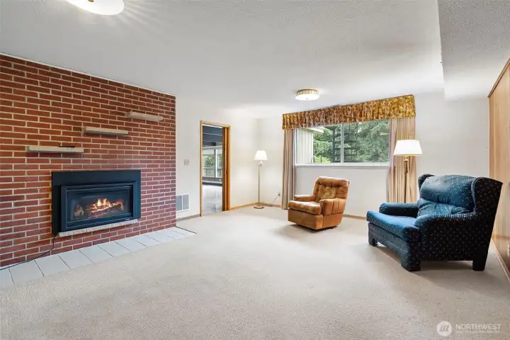 Living space in the basement with cozy gas fireplace.