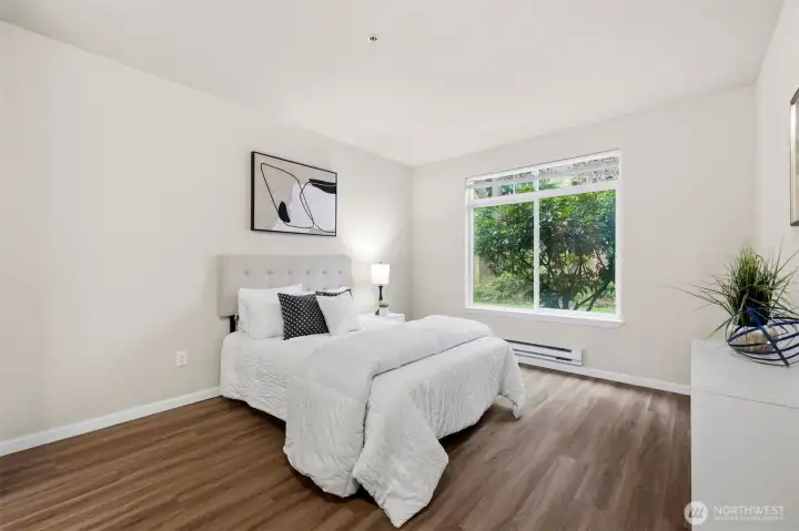 Spacious primary bedroom with natural light and peaceful setting.