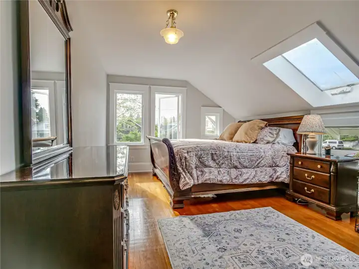 The Primary bedroom easily handles a king sized suite of furnishings. Notice the skylight.