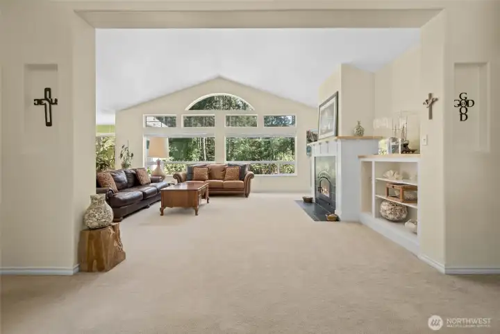 Wall of windows filters in brilliance into this spacious vaulted ceiling living room.