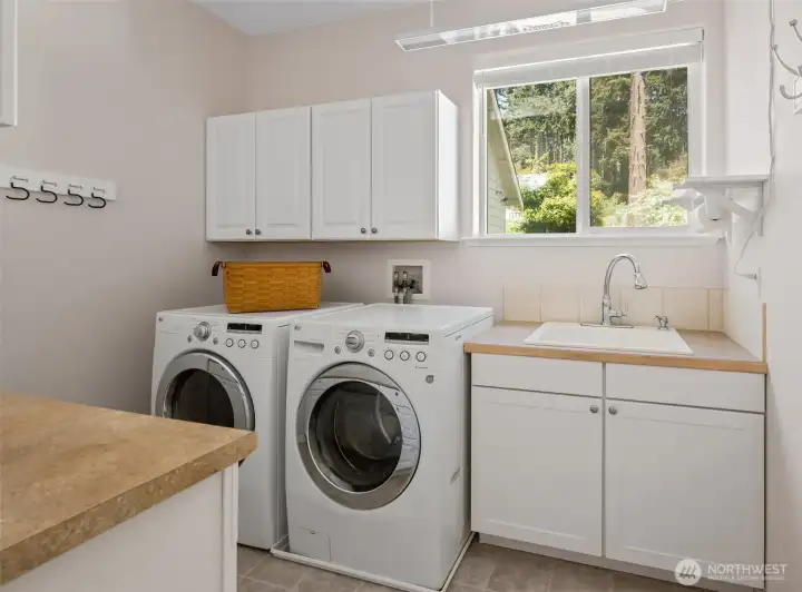 Spacious laundry room with window and utility sink.
