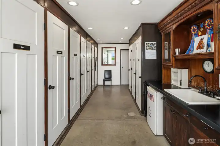 Tack locker room boasts lovely finishes inside with sink and refrigerator