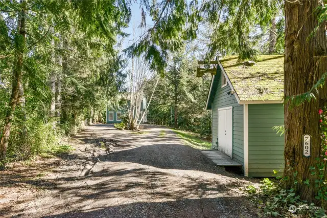 Entering the property you come down the tree lined driveway, past this additional building with power, on your way home!