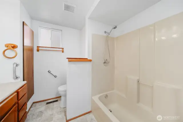 Full bathroom with new flooring and new toilet.