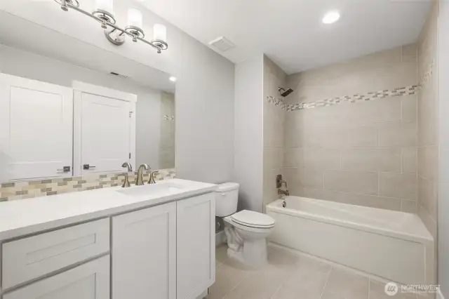 The fresh and bright lower level bath is conveniently assessible from both the secondary guest suite and the bonus/rec room.