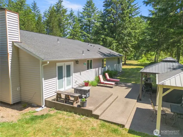 Back deck area with seating area and 2 metal roof gazebos.