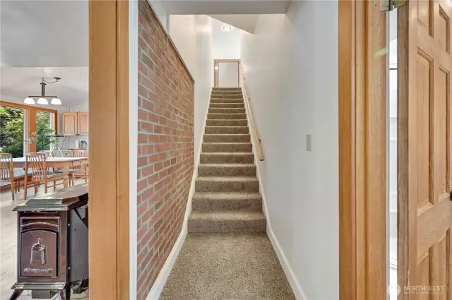 Stairs to primary suite. Second bedroom behind, full bath to left.