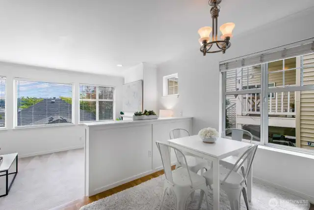 Light-filled dining area off kitchen with peek into sunken living room