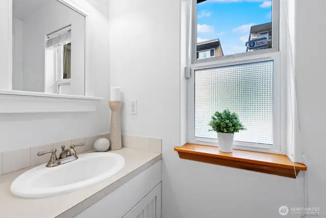Bright main-level powder room with natural light and crisp finishes.