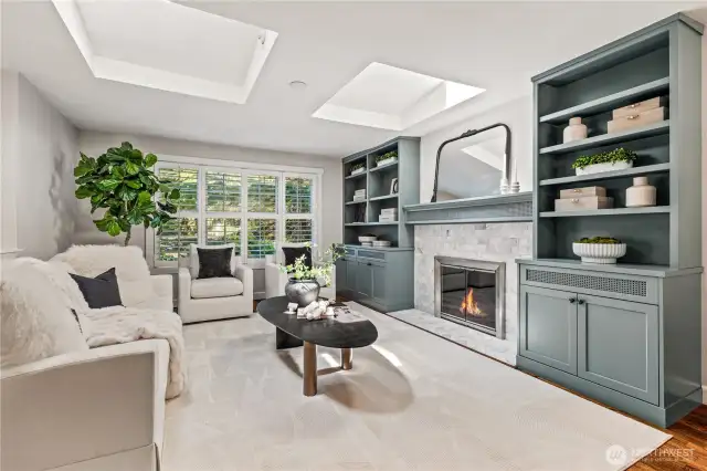 As you walk upstairs, you'll be greeted by sunlight streaming through the skylights in the living room, a beautiful wood burning fireplace, and custom built-in shelves perfect for showcasing your favorite books, art, or collectibles