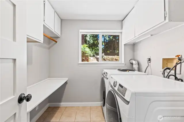 A convenient separate utility room houses the washer, dryer, and cabinetry for extra storage