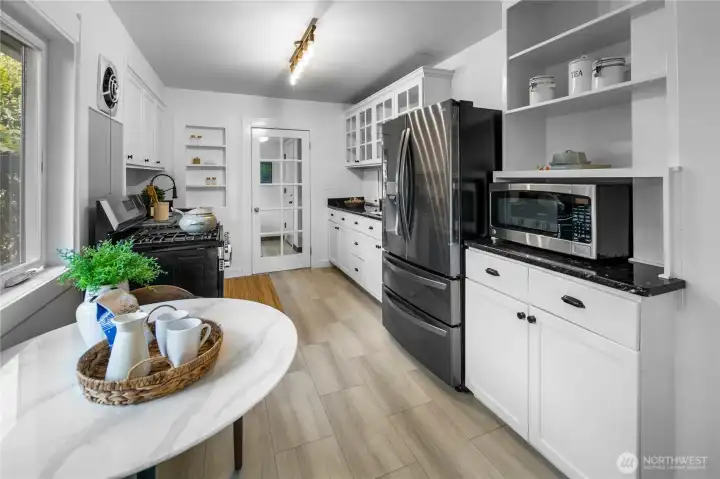 Kitchen has lots of storage and has also been recently updated with new luxury vinyl tile floors, new stove, lighting and newer refrigerator too. Through the door you'll find the mud room, washer/sryer, and back door leading to the yard, basement, garage and "Casita"