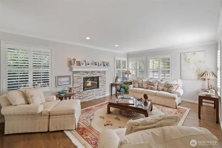 The elegant sunken living room exudes both sophistication and comfort. Gleaming hardwood floors and carefully chosen finishes enhance the room’s warm, inviting atmosphere. Large windows fill the space with natural light, while the sunken design creates a distinct, intimate area perfect for conversation, relaxation, or entertaining guests.
