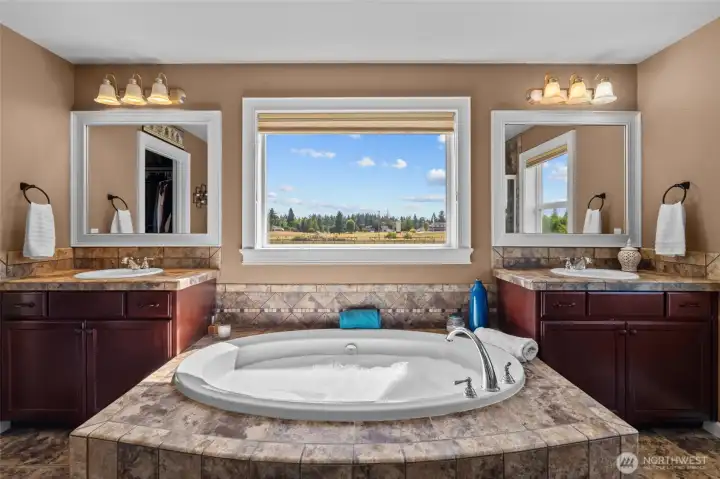 The soaking tub offers a serene, spa-like retreat, with a window that captures the grandeur of Mt. Rainier.