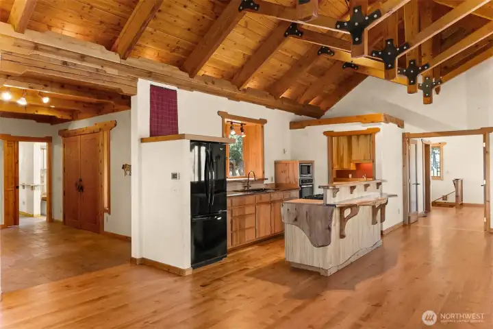 A practical open kitchen sits at the heart of the home with a custom island, large walk-in pantry and the coolest countertops. To the left, the main entry with a hallway beyond that leads to the primary bedroom, studio apartment, and garage. To the right, a flex space that makes an ideal reading area, office, or even extra sleeping space with a 3/4 bath and access to the daylight basement.