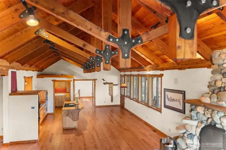 Massive beams and river rock fireplace create a warm and welcoming space in the main living area, which actually feels even larger in person than it appears in photographs!