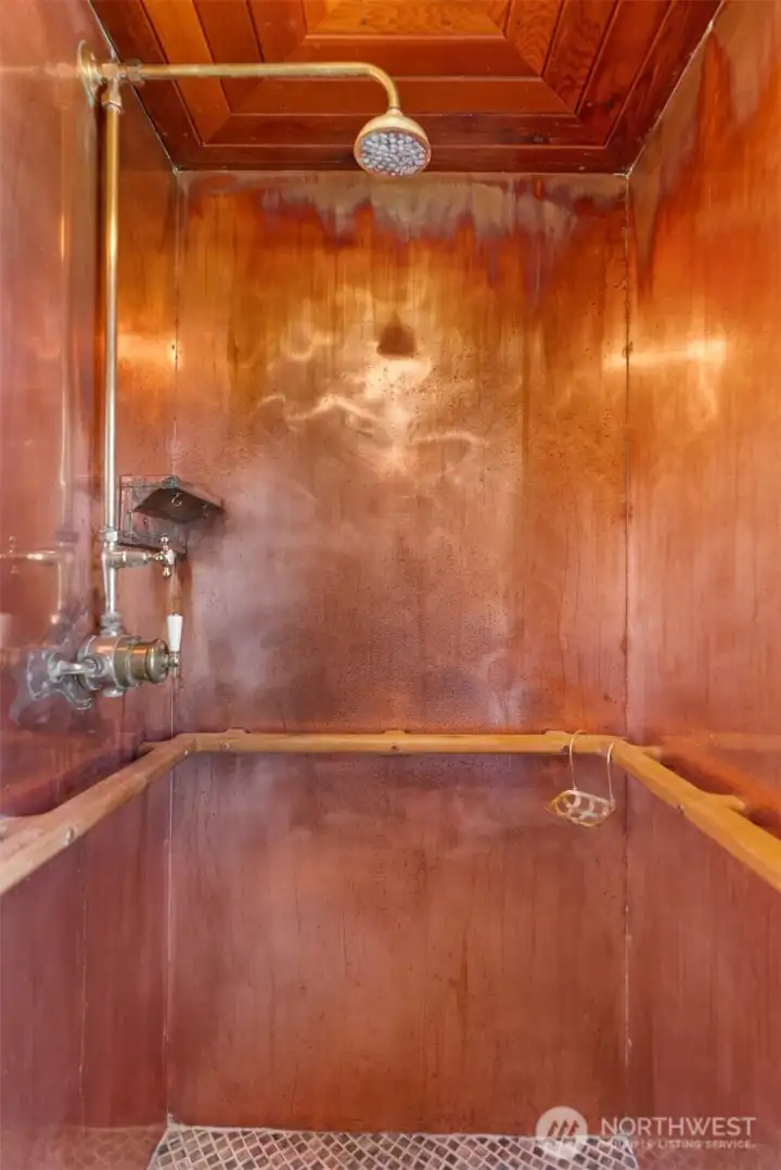 The delightful surprises keep coming, like this copper-wrapped shower in the primary suite.