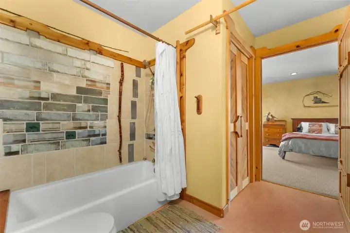 Full bathroom in the studio apartment with custom wood and tile details.