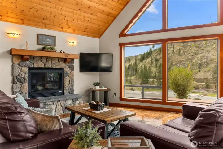 Propane fireplace in river rock hearth adds ambiance and practical warmth.