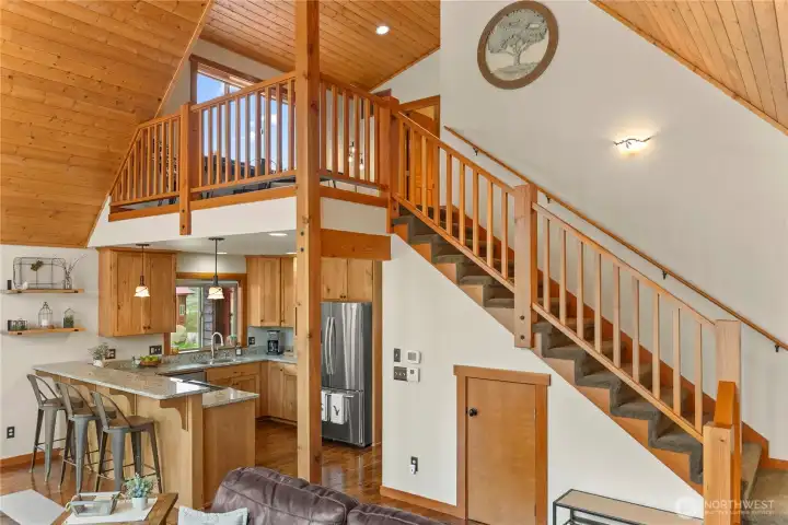 Open floorplan with stairs leading to a second floor loft, bedroom, and bathroom.