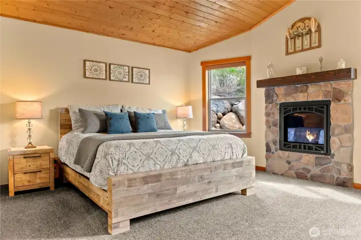 Primary bedroom with propane fireplace for warmth and ambiance.
