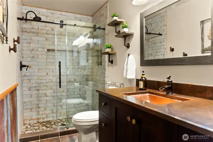 Designer tile, copper sink, granite countertops, and distressed metal accents are featured in this 2021 bathroom remodel.