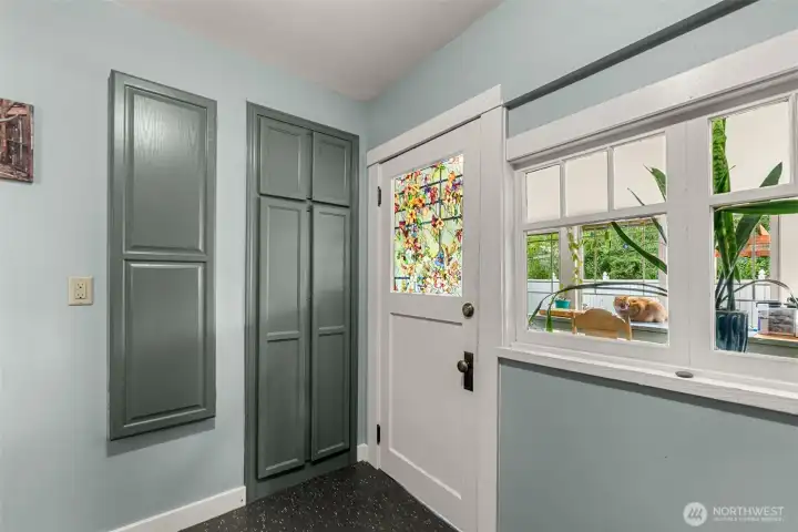 Laundry Room storage and built in ironing board. Door to sun porch area.