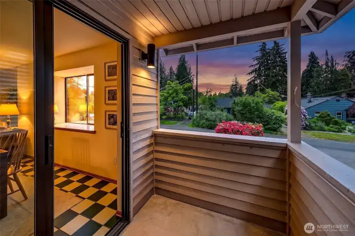 A covered outdoor space overlooking mature evergreens, extending the home's living and entertaining areas beyond the interior walls.
