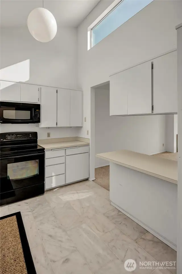 Kitchen is graced with natural light flooding into it