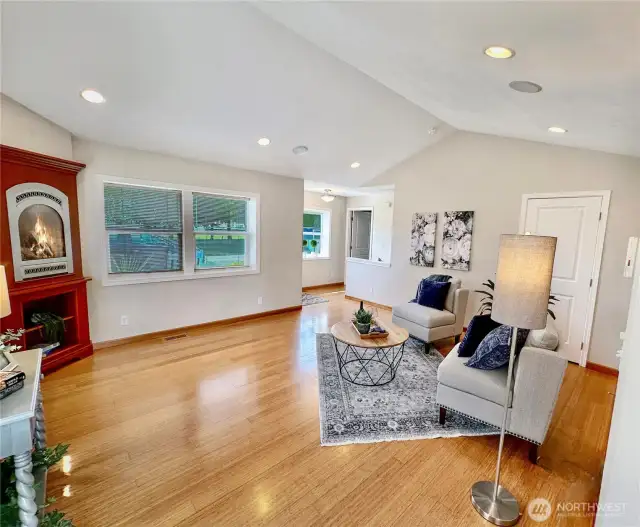 Another view...in this photo you see the charming corner gas fireplace, hall that offers access to the front door, stairs to the family room and door to main floor primary bedroom.