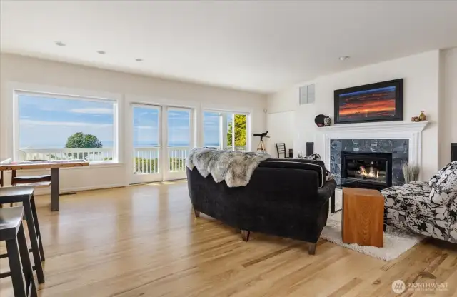 Great Room-style Living Room, Dining Room & Kitchen area on the 2nd level. Hickory flooring, propane gas Fireplace with slate surround and built-in WiFi stereo speakers.  French doors out to the 2nd level deck with views of the Sound & mountains.