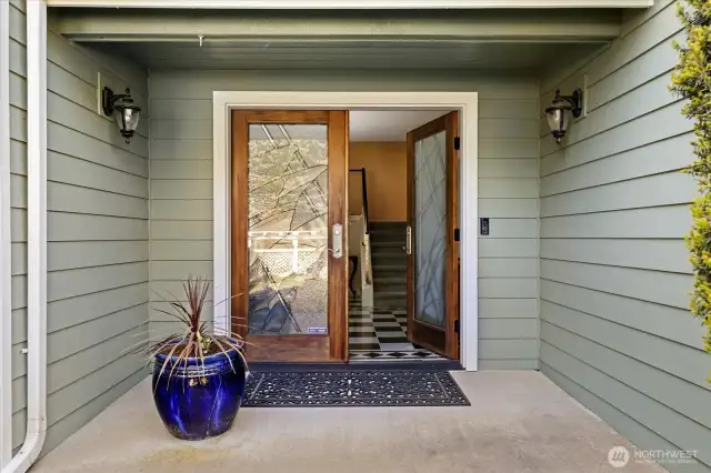 Large front porch and entry through the double doors to the custom-built home.