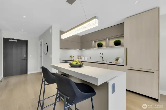 Beautiful Kitchen with 2 tier island counter and custom installed lighting above, built in fridge and cabinets