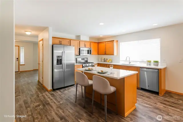 Open updated kitchen.  Stainless appliances  and island with eating space.