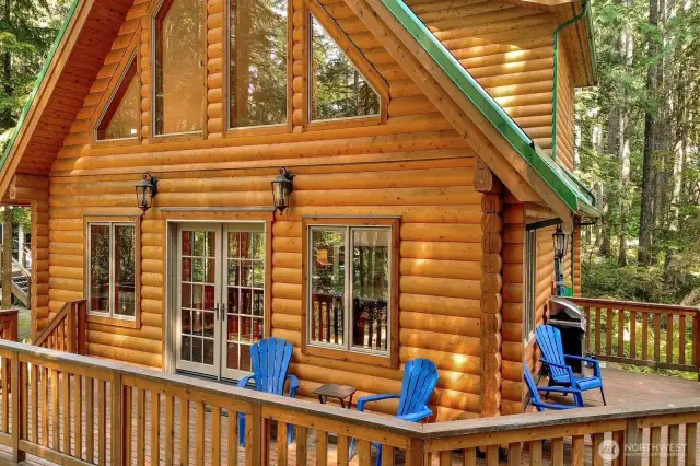 Porch wraps around the side of the log home