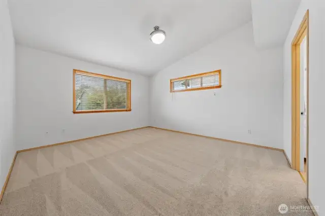 Primary bedroom is located on the backside of the home for extra privacy, the large window overlooks the backyard.