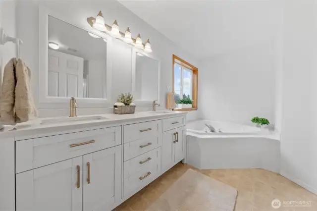 The primary en-suite with quartz countertop, dual sinks, soaking tub, stand-alone shower and deep walk-in closet.